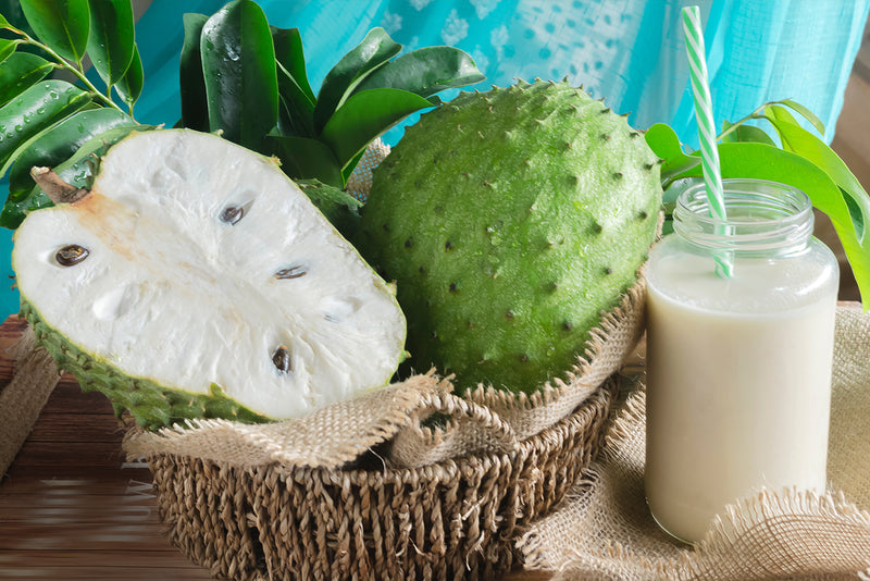 Graviola or "Soursop" fruit in a bowl next to a juice